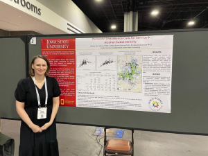 Kelsey Van Selous poses in front of a research poster