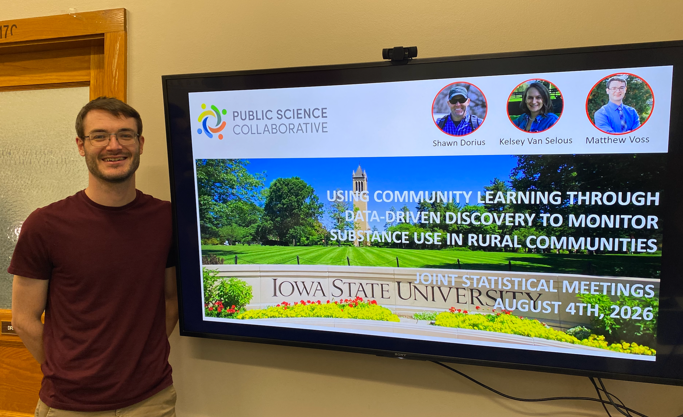 Matthew Voss standing beside a presentation screen
