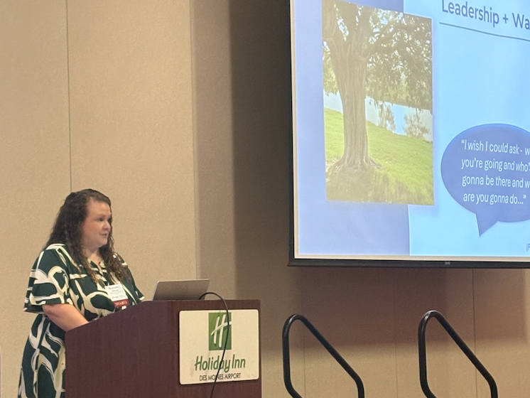 Mackenzie Johnson presents at a podium at a conference